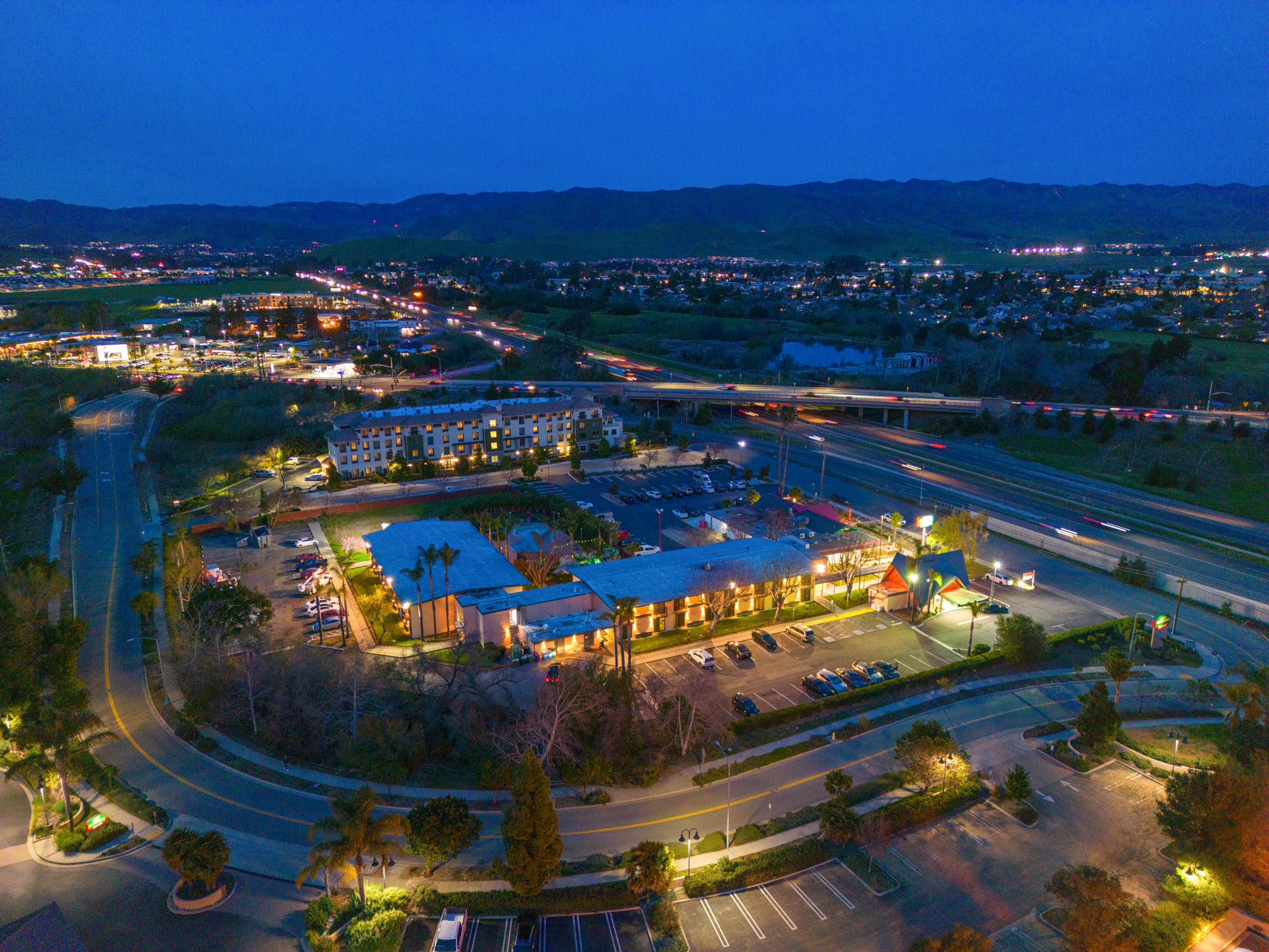 An aerial view of a hotel and its surroundings at dusk.